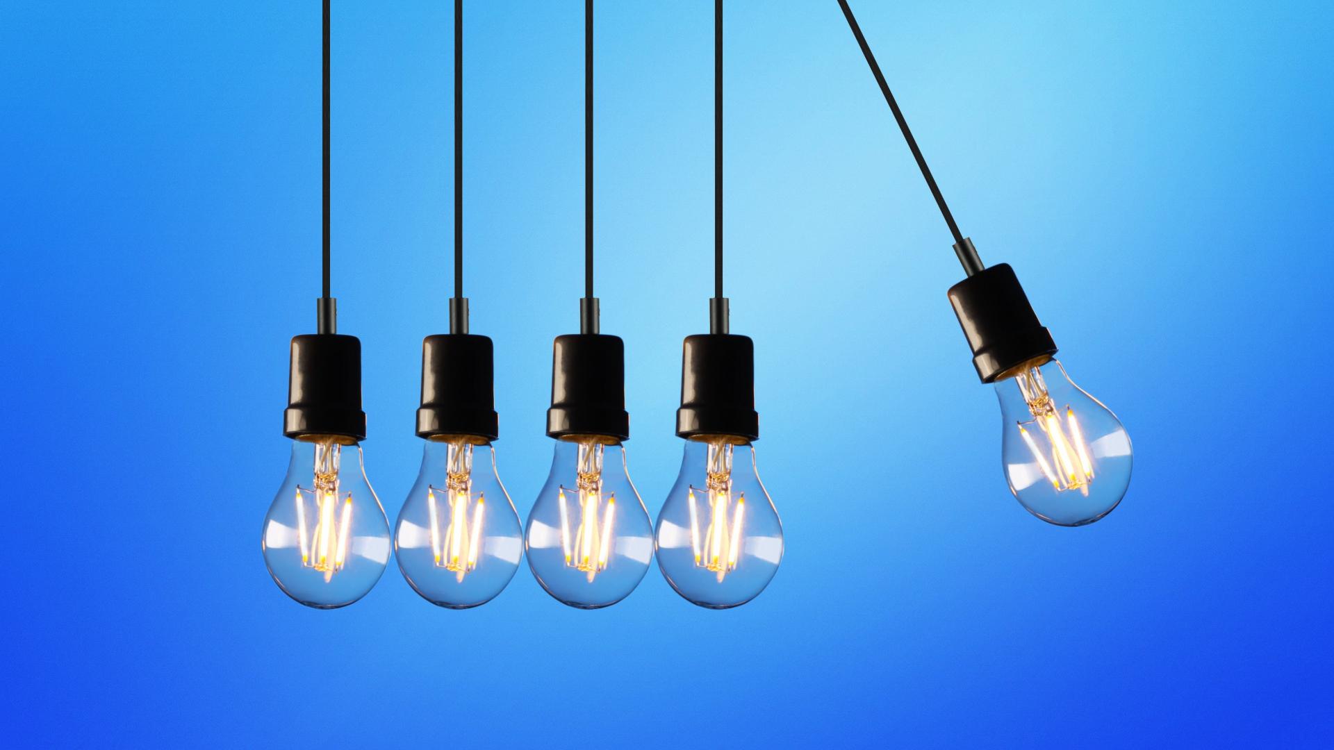 Five light bulbs hanging with one moving