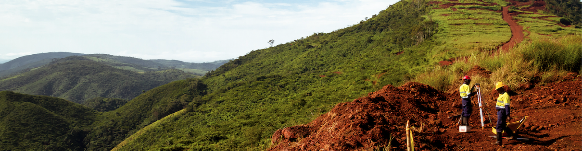 Mining construction workers surveying mountain top in Africa