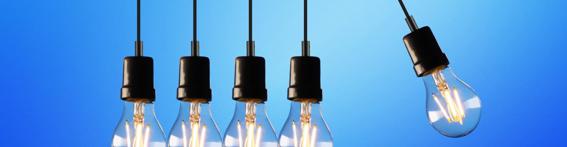 Five light bulbs hanging with one moving