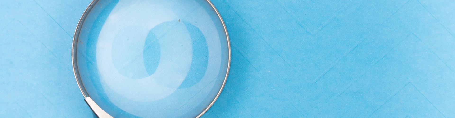 Magnifying glass against a blue background