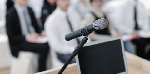 A microphone and a laptop on the table in a board meeting space