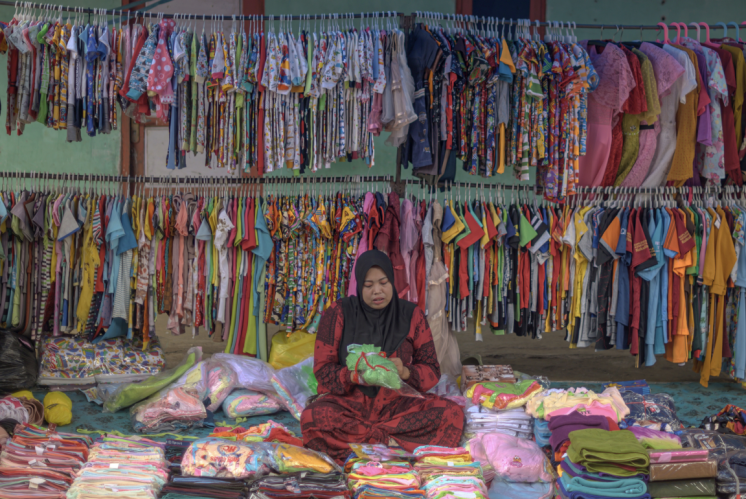 A woman runs a clothing business in a traditional market of the Toara village In North Morowali.